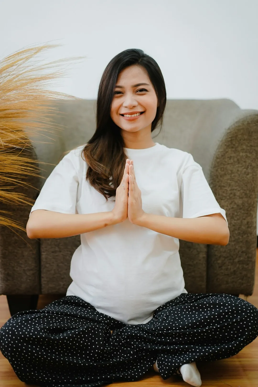 pregnant woman sitting in a yoga pose smiling