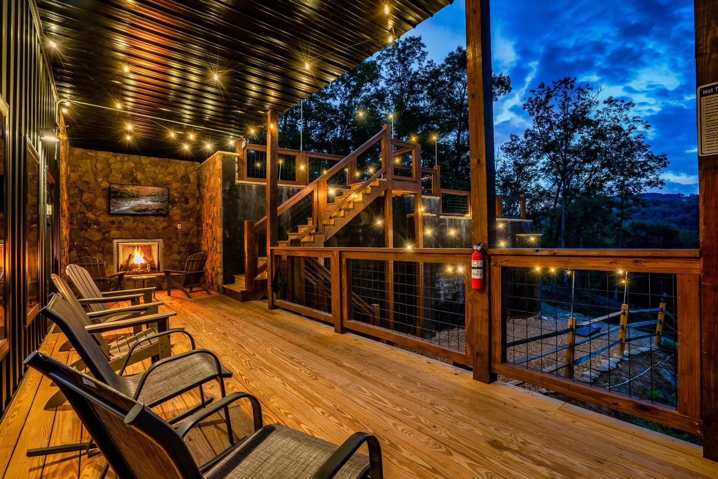 Lower covered deck — rocking chairs, outdoor fireplace, and hot tub