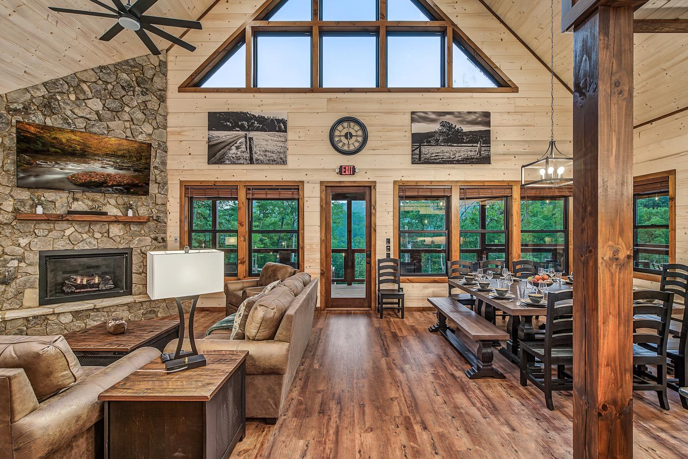 Great room — soaring cathedral ceiling, dining, and stone fireplace