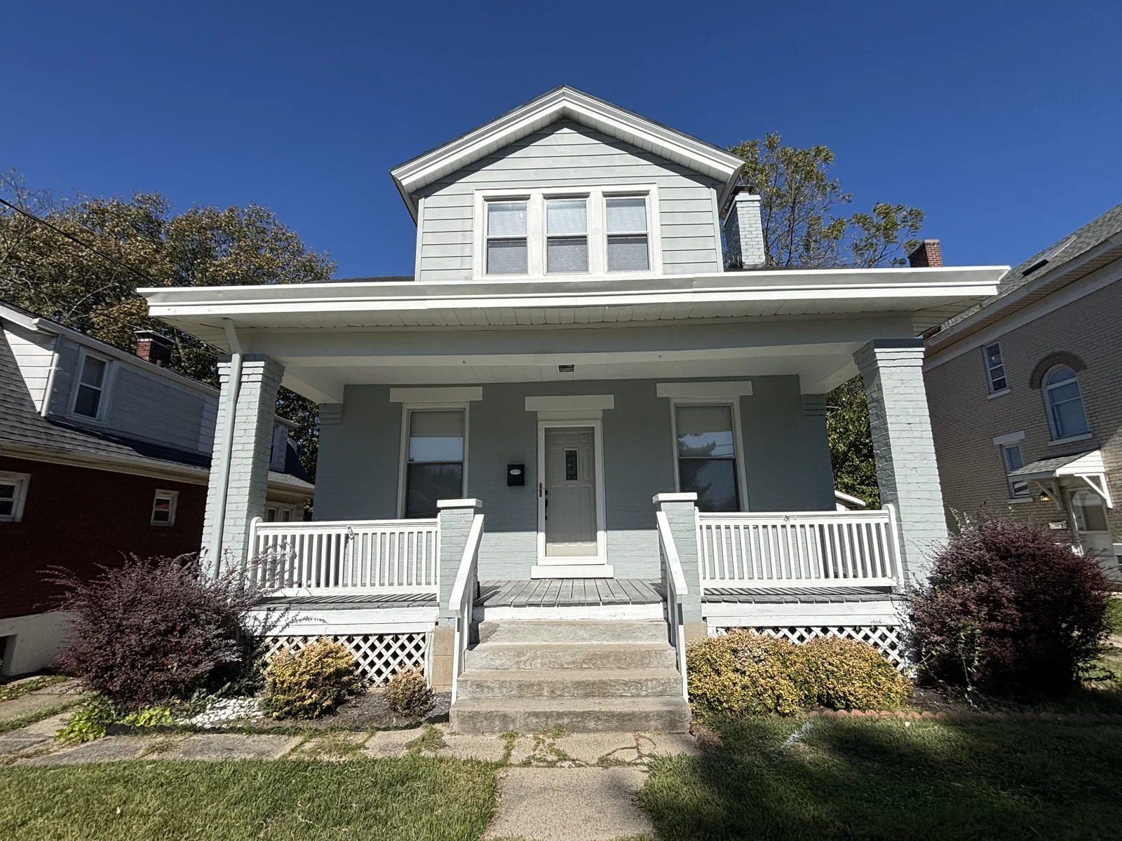 Exterior detail showing painted siding, trim, shutters, and door completed by Quality Painters