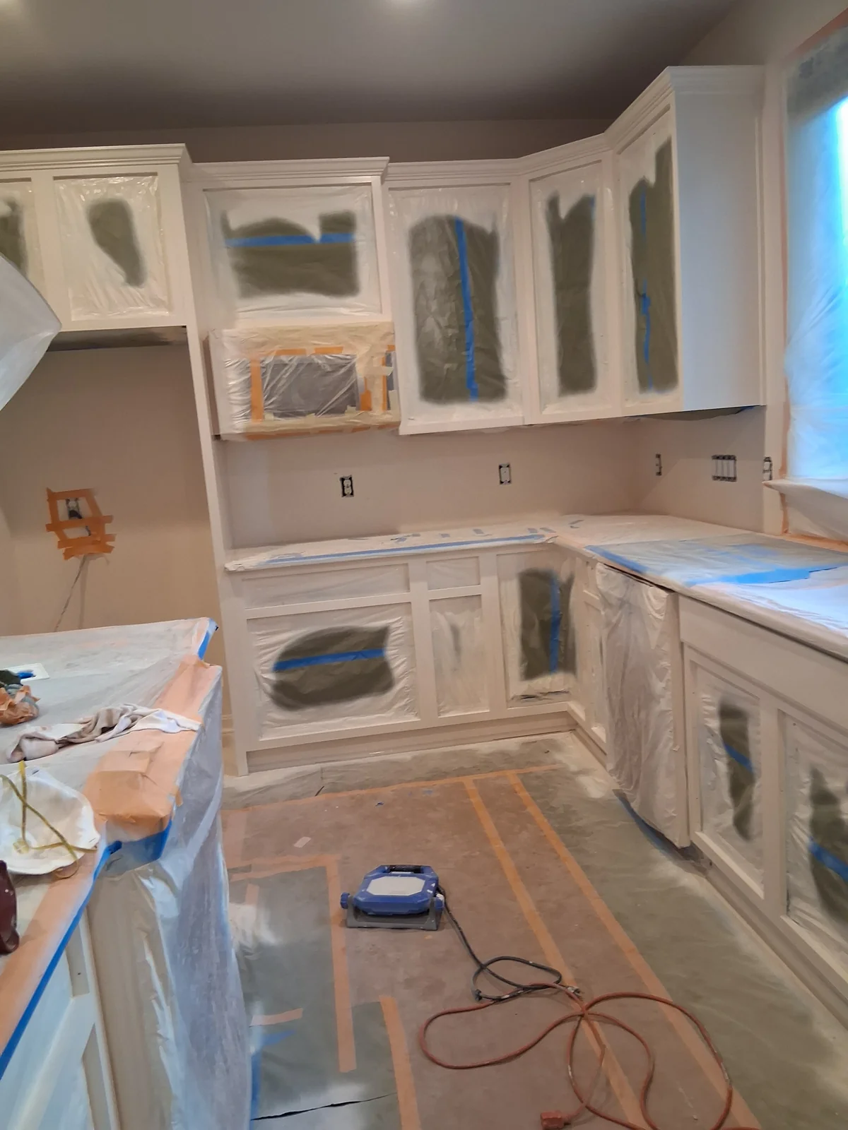 Cabinet painting preparation showing cabinet doors, drawer fronts, and surface detail before finishing