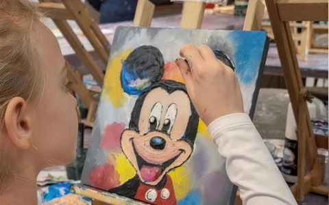 Fetiță la atelierul de pictură pentru copii, care pictează la șevalet