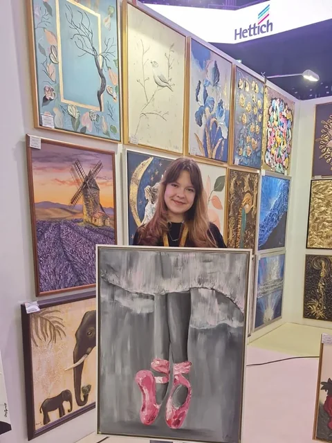 Fată cu tabloul ei la expoziție