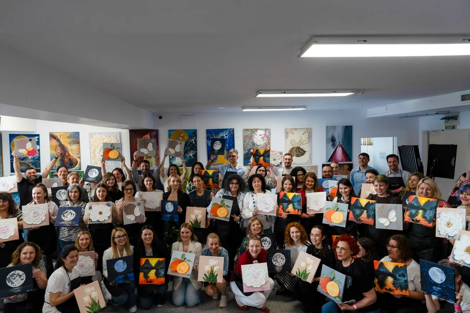 Toată echipa, cu tablourile ei în relief, la final de team building