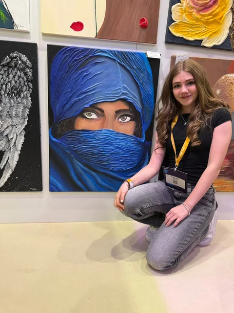 Fată lângă tabloul ei expus la Decodays, expoziție de design interior