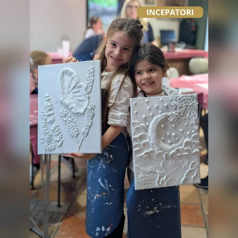 Două fetițe cu tablourile lor în relief, la Atelierul de Descoperire