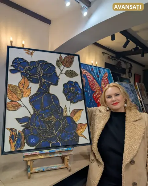 Cursantă de la Avansați lângă tabloul ei mare