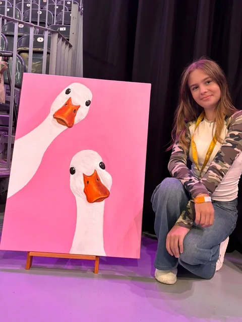 Fată lângă tabloul ei cu două gâște, la expoziție