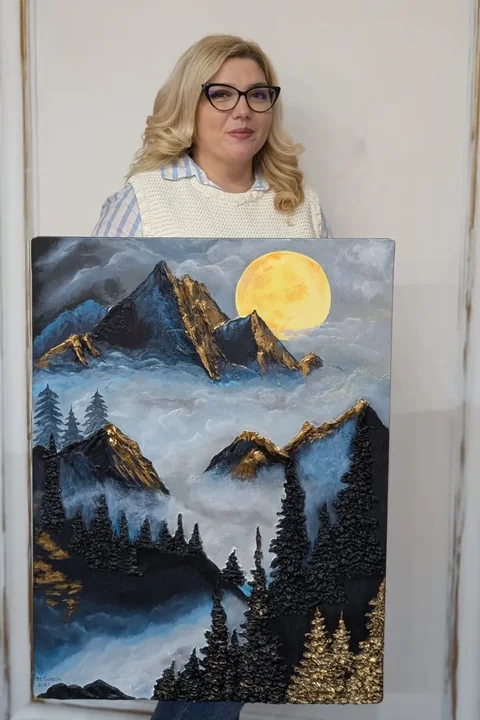 Mădălina Simion cu tabloul ei în relief „Misterul înălțimilor”: munți, ceață și lună plină
