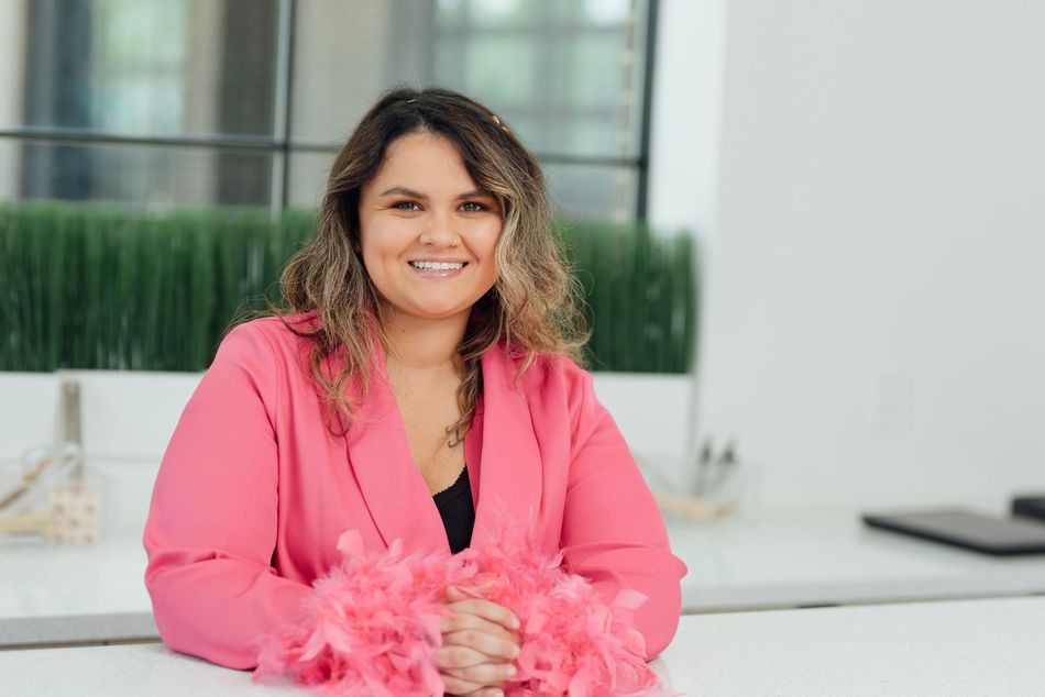 Kassandra Nordhoff, head event planner at Black Tie Flair, smiling in a pink blazer