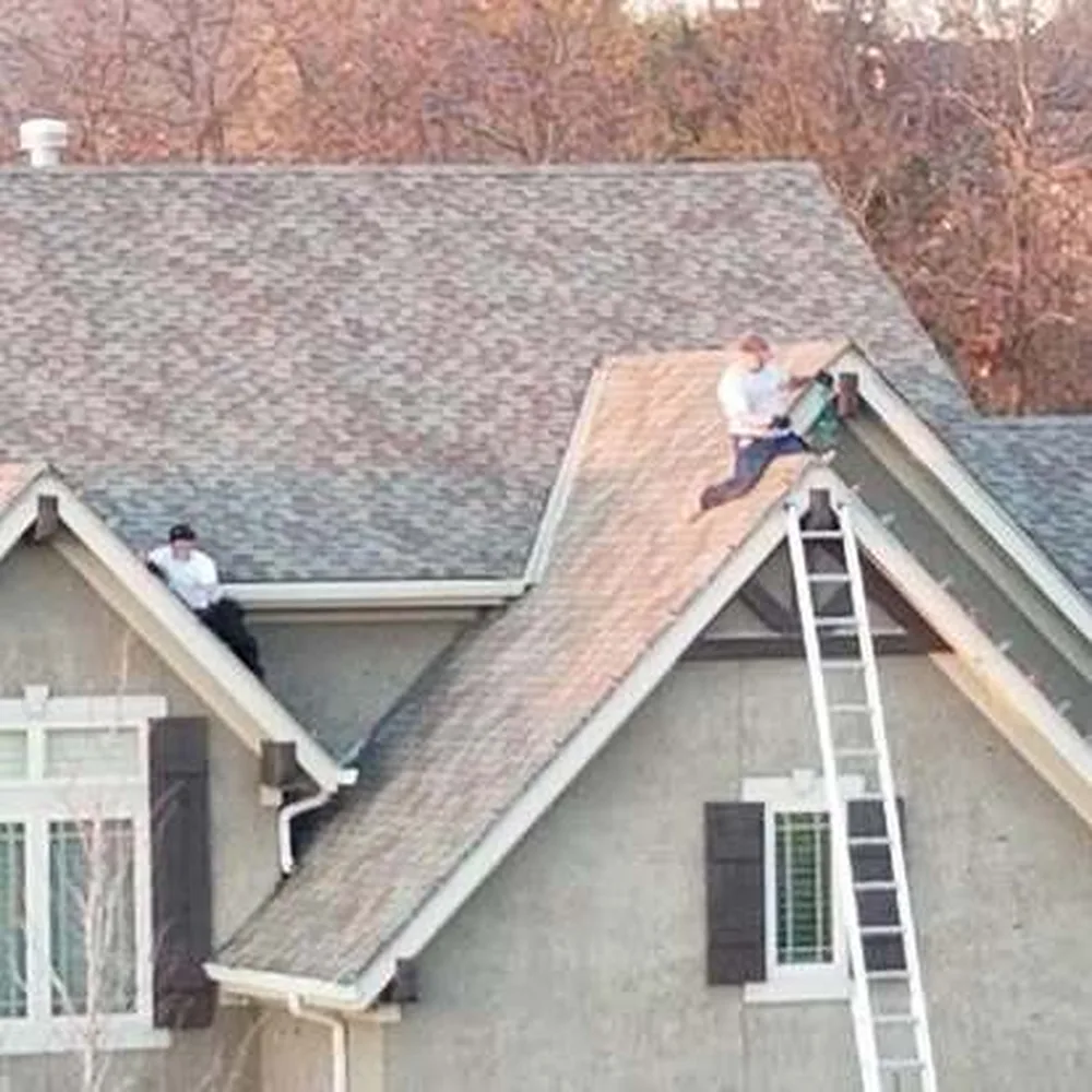 Crew installing warm white C9 bulbs along a steep rooftop peak in daylight