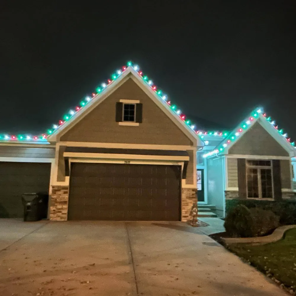Red and blue C9 bulbs outlining a ranch home at dusk