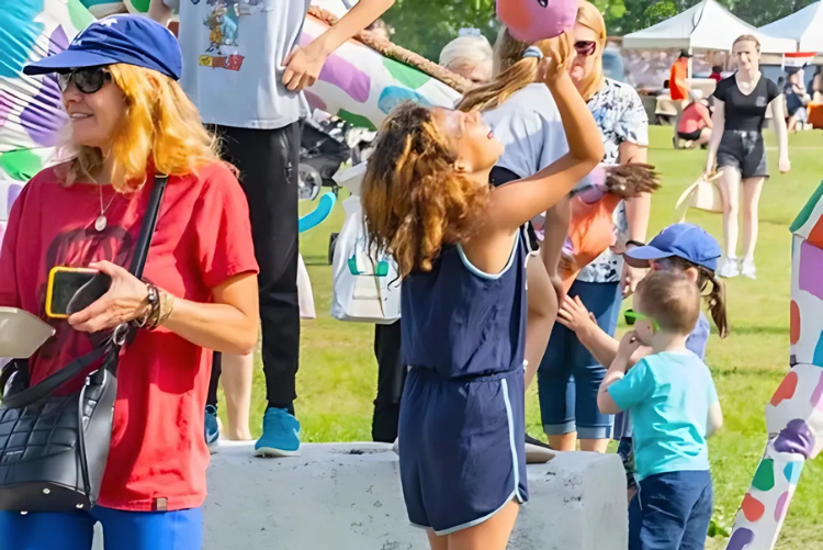 Children and families enjoying outdoor activities and colourful sculptures during a sunny day at Pop-Ups on the Bay in Belleville.