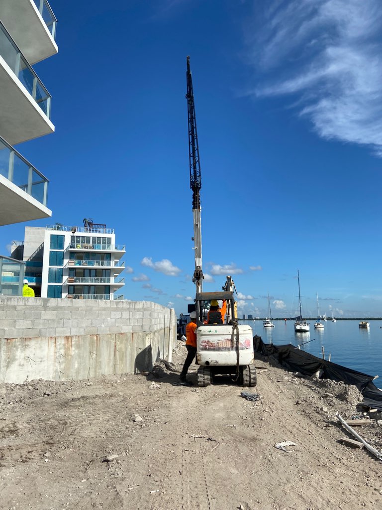 Compact pile installation equipment operating on a South Florida waterfront construction site