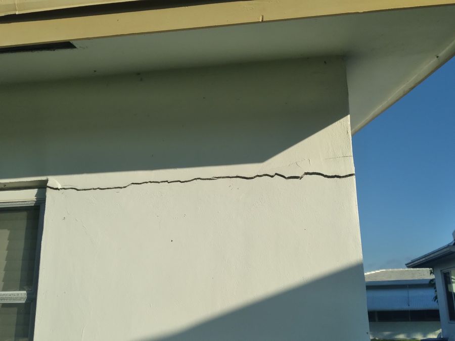 Before: horizontal crack along the corner of a stucco house