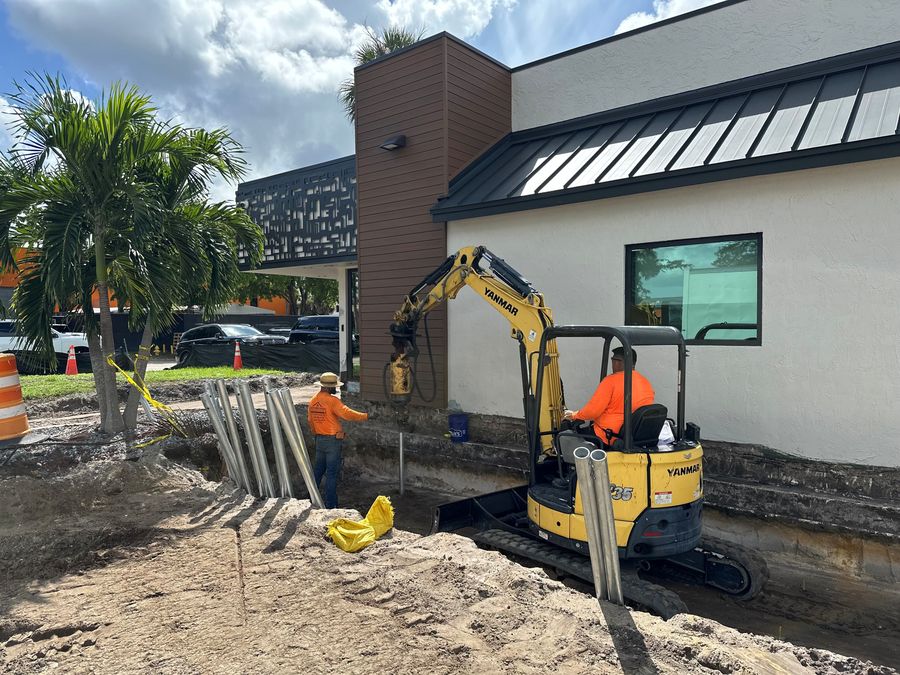 SCFS crew installing a steel pile beside a commercial building