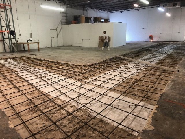 Rebar mat over vapor barrier during an interior slab rebuild