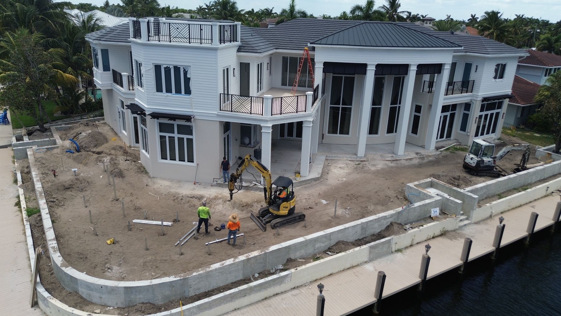 Aerial view of pile installation in front of a waterfront home under construction