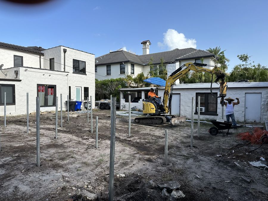 Grid of installed galvanized pipe piles on a residential lot