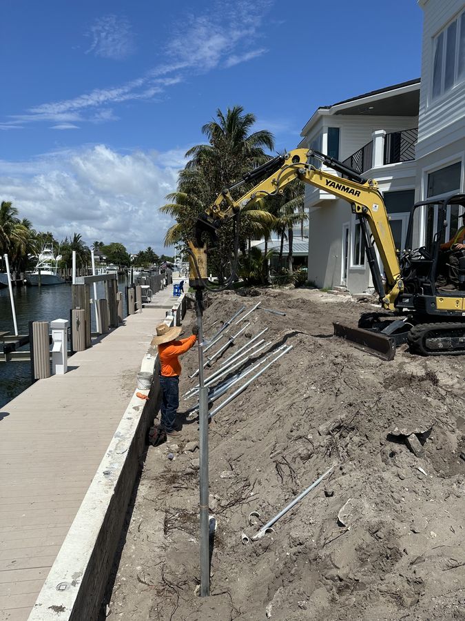SCFS crew member guiding a galvanized pile into place at a waterfront lot