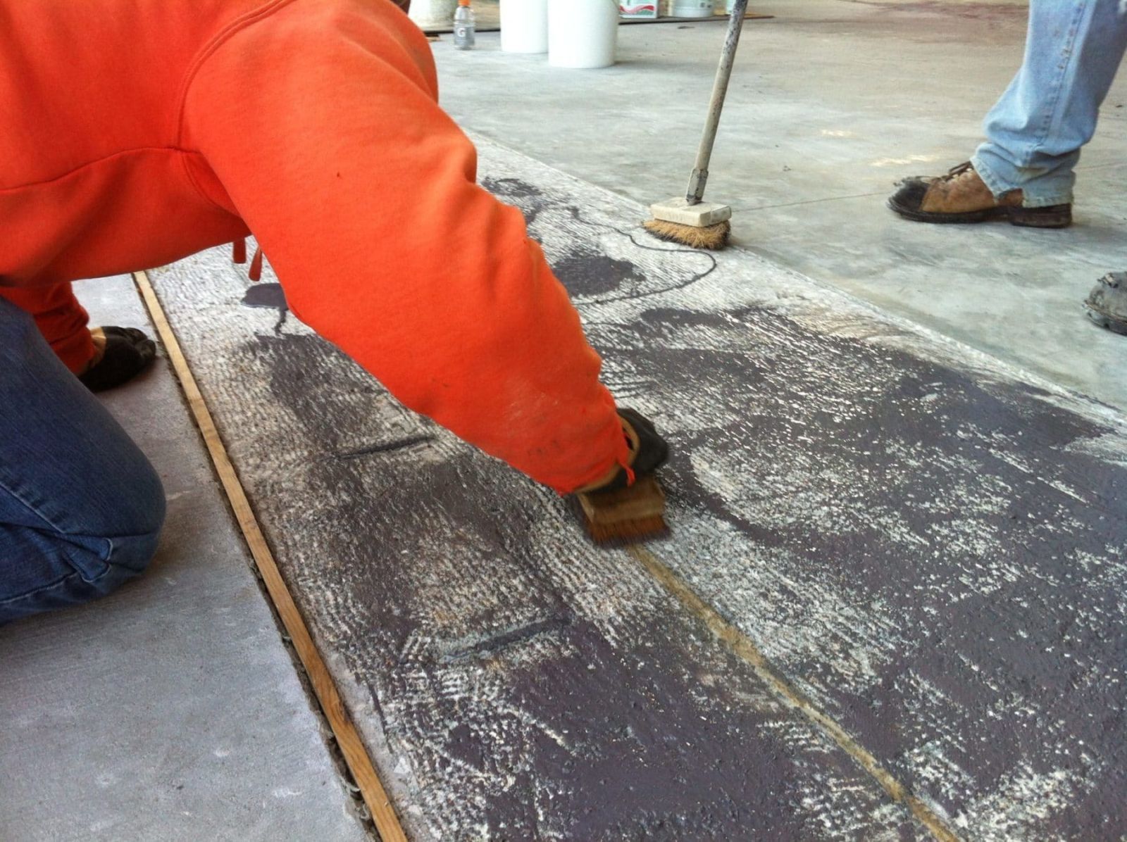 SCFS crew member working a concrete surface by hand during a restoration project