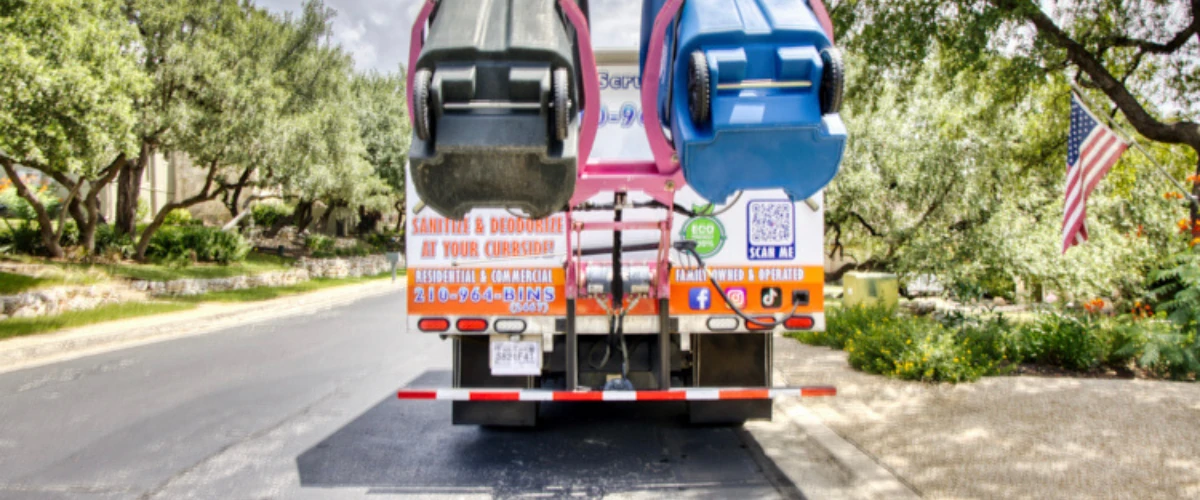 Trash can cleaning truck lifting two bins for eco-friendly sanitizing and deodorizing. Trash can cleaning truck lifting two bins for eco-friendly sanitizing and deodorizing.