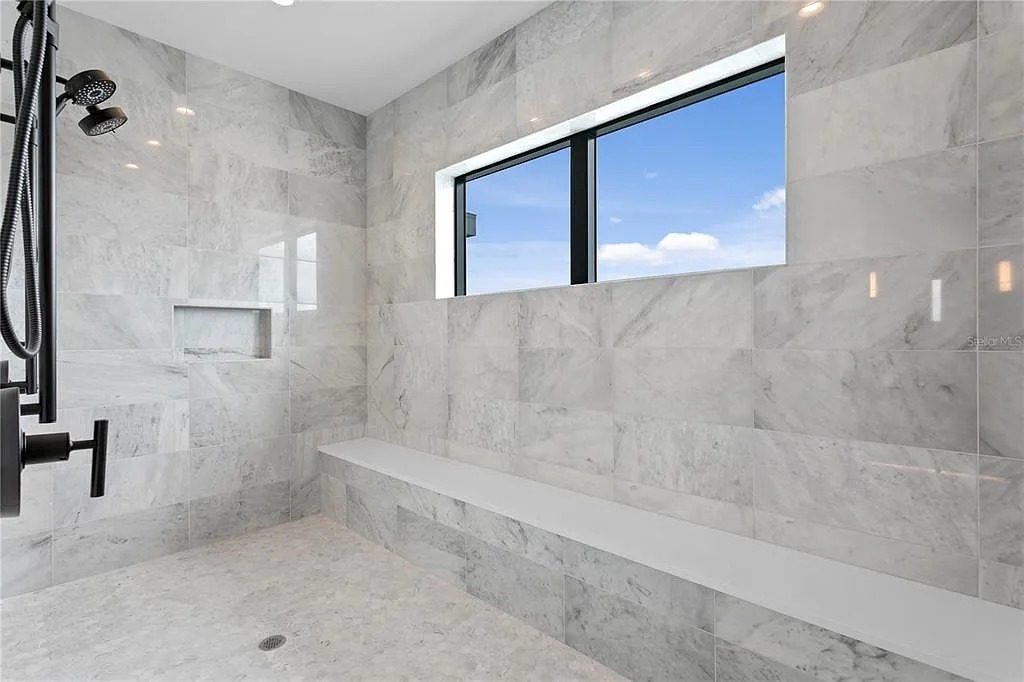 Walk-in shower with stone walls and bench