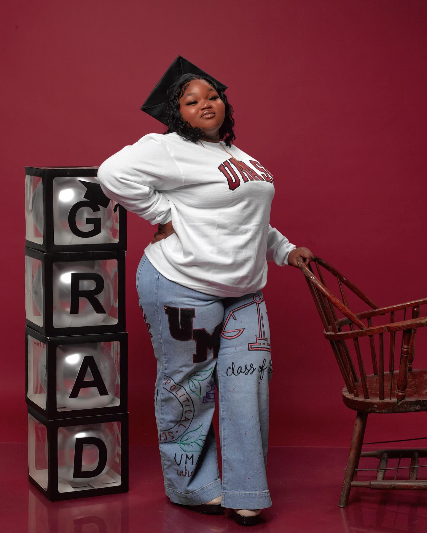 Close-up portrait of a woman outdoors holding her graduation diploma