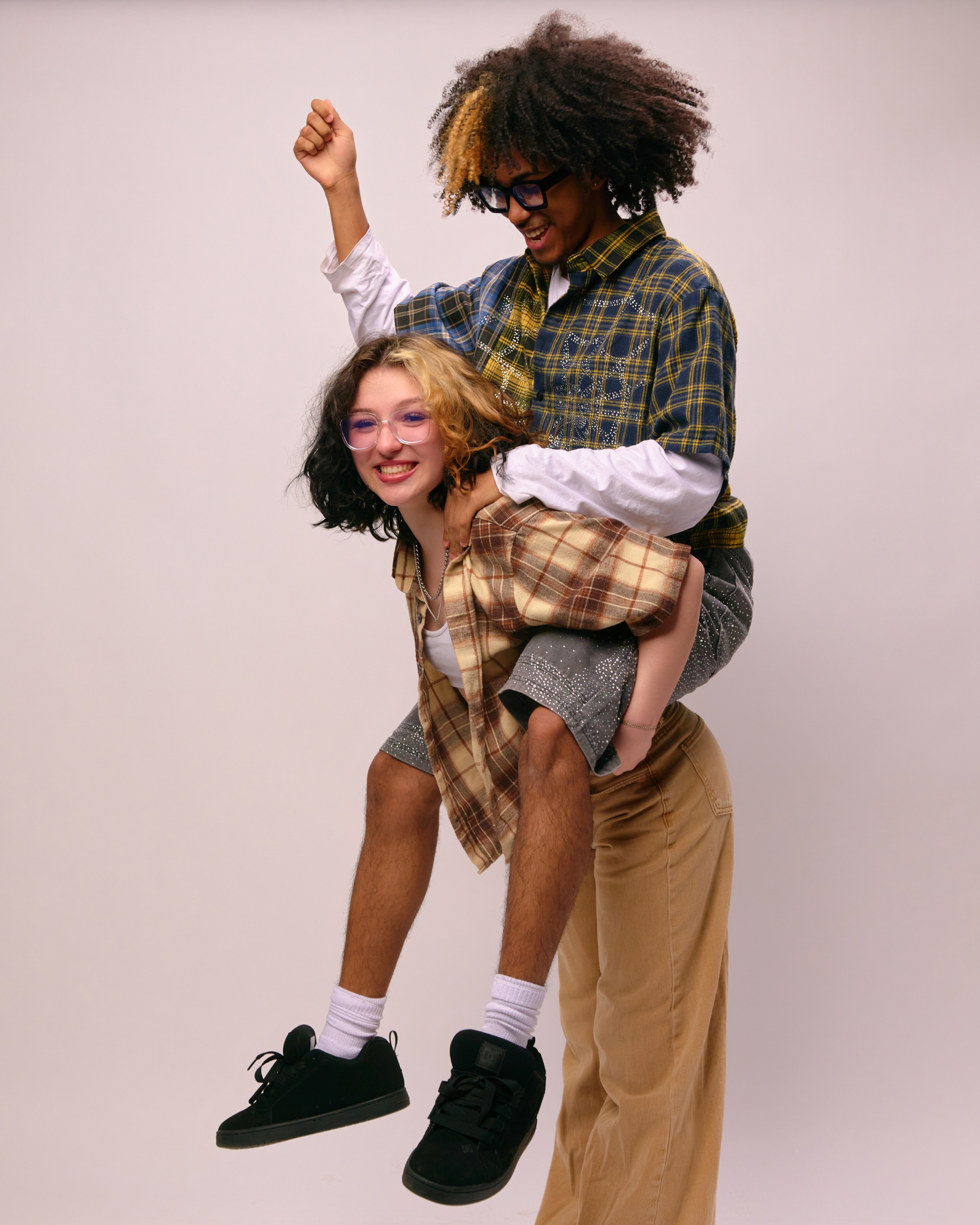 Portrait of two young men posing closely together against a white background