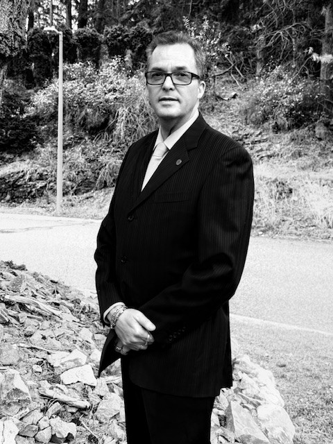 Black-and-white portrait of Riel standing outdoors