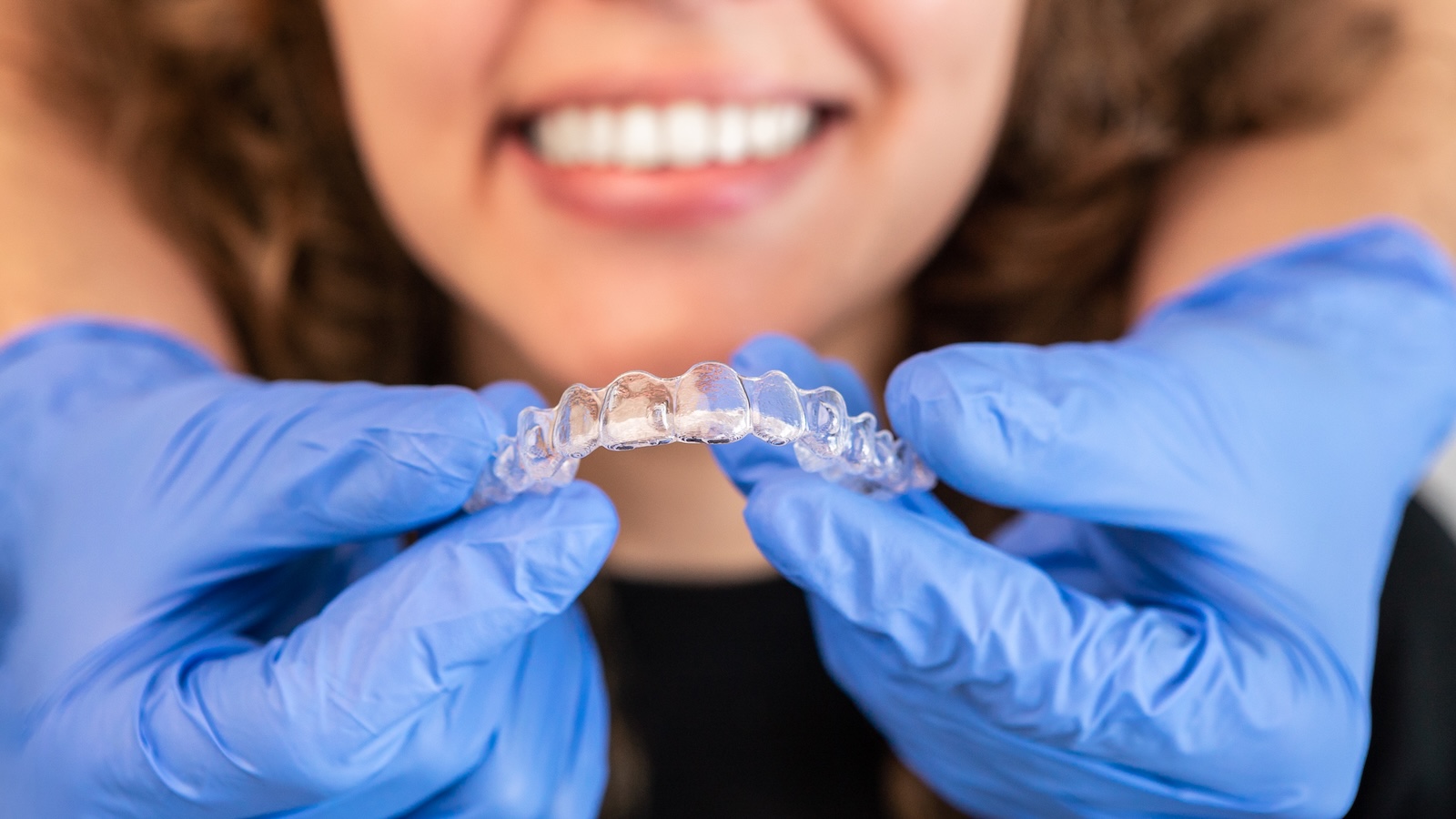 Woman with a straight, confident smile after Invisalign treatment at Impact Dental Liverpool