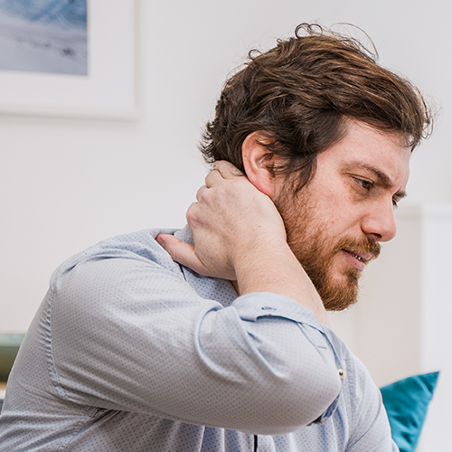 Man holding his neck in discomfort, seeking effective treatments for neck pain and whiplash at Naturopathic Physicians Group.