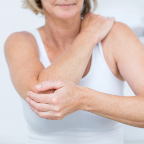 Woman addressing tennis elbow discomfort, symbolizing natural treatments for elbow pain.