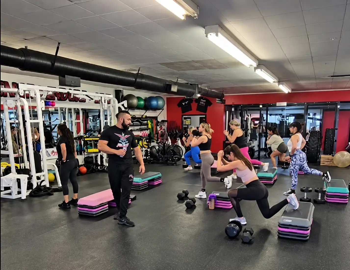 Group fitness class performing lunges and strength exercises at Xcel Fitness