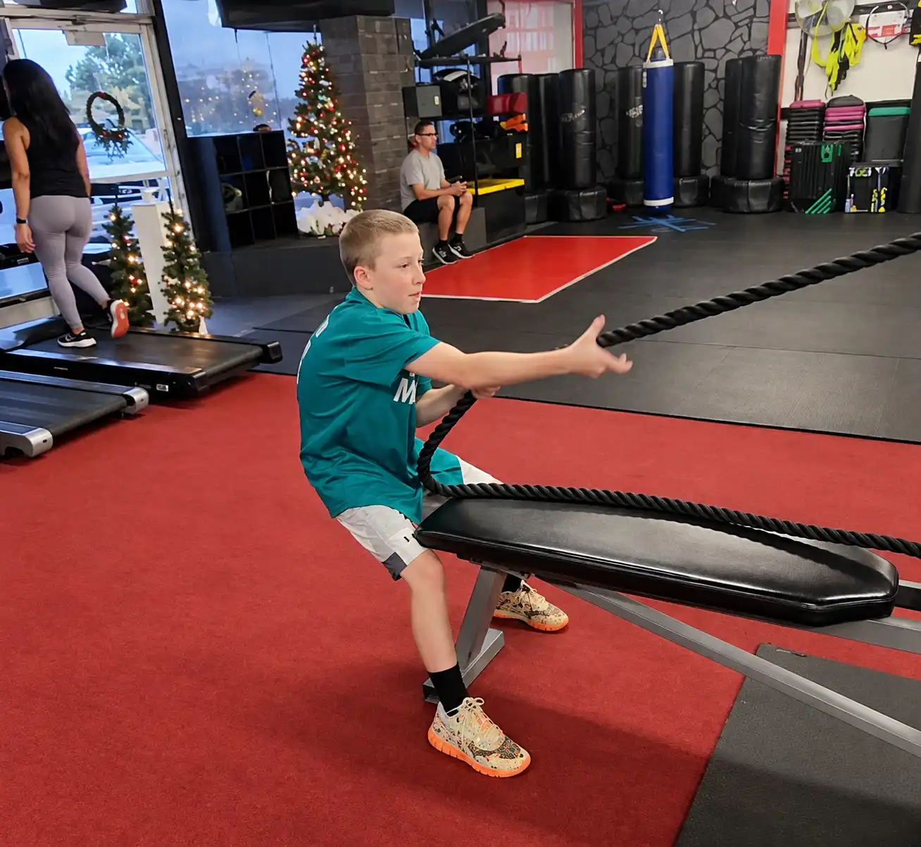 Young athlete training with battle ropes at Xcel Fitness