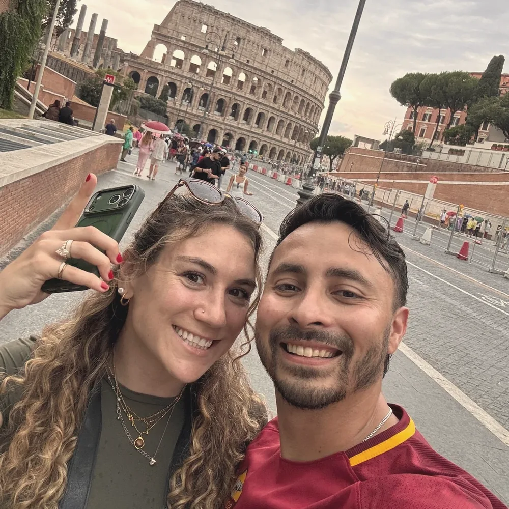Elise and Ricardo taking a selfie in front of the Colosseum in Rome