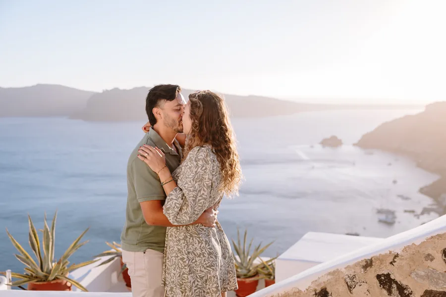 Elise and Ricardo hold each other at the wall, her arms around his neck