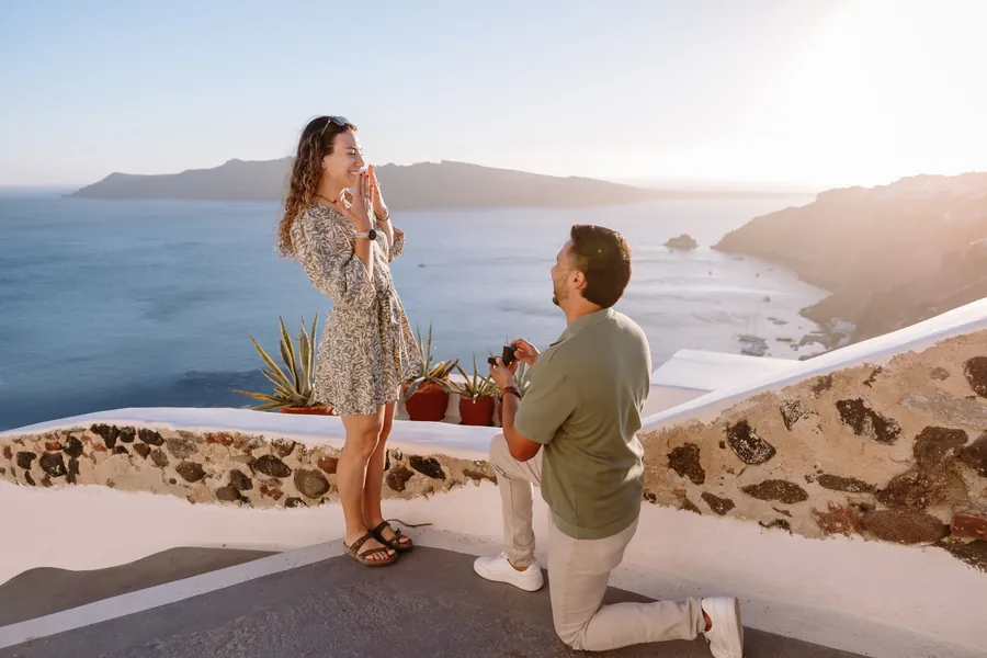 Ricardo on one knee holding the ring up to Elise