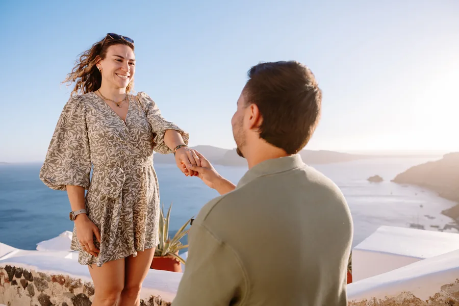 Elise beaming at Ricardo, holding both of his hands, right after the yes