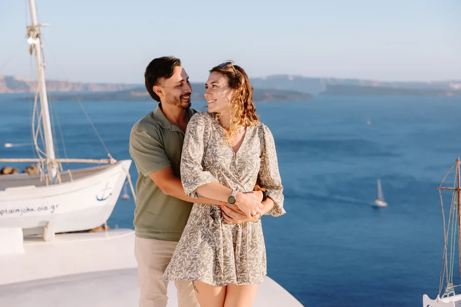 Ricardo holding Elise from behind on the rooftop, both laughing