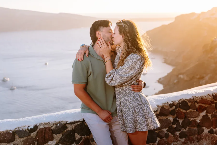 A kiss at the stone wall, the sun flaring behind them