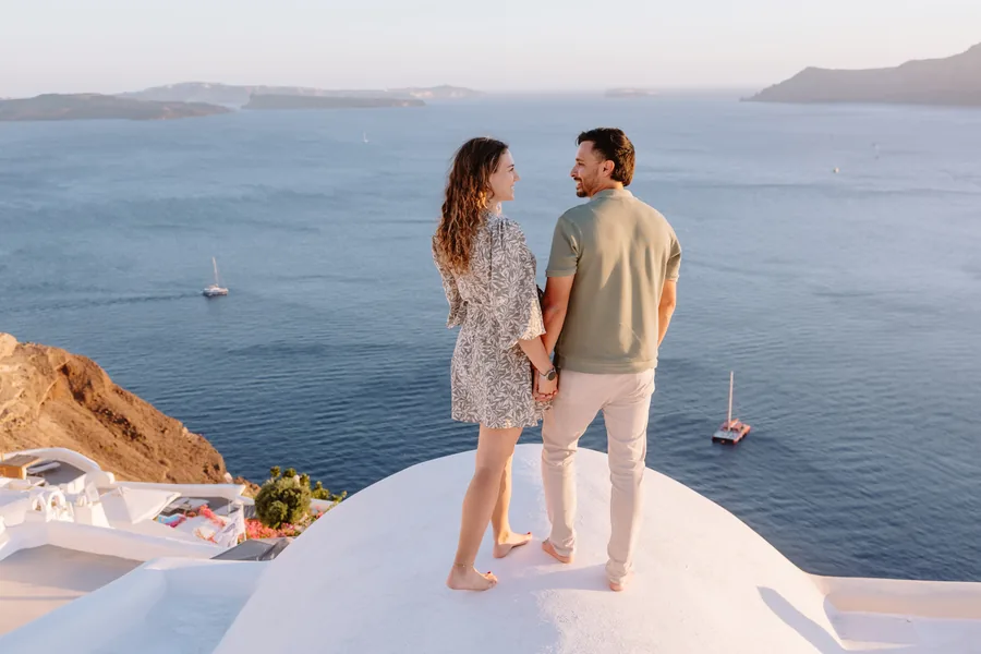 Standing on the dome holding hands, looking out to sea