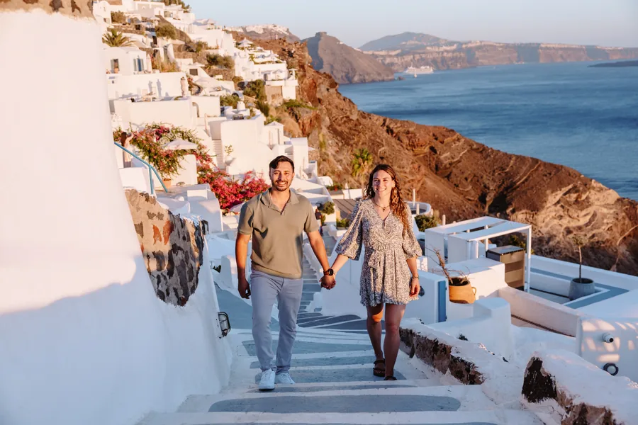 Walking down the steps hand in hand, the blue of the bay opening up