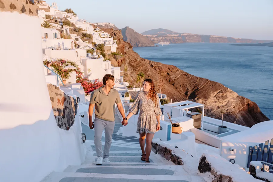 Coming down the steps together, the cliffs of Oia glowing