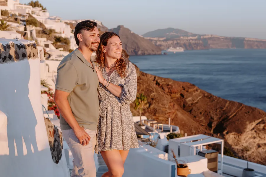 Ricardo holding Elise close on the steps, the caldera cliffs behind
