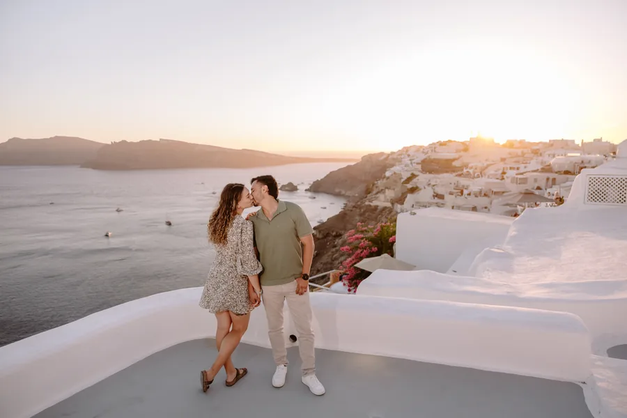 A kiss on the terrace, the sun setting behind
