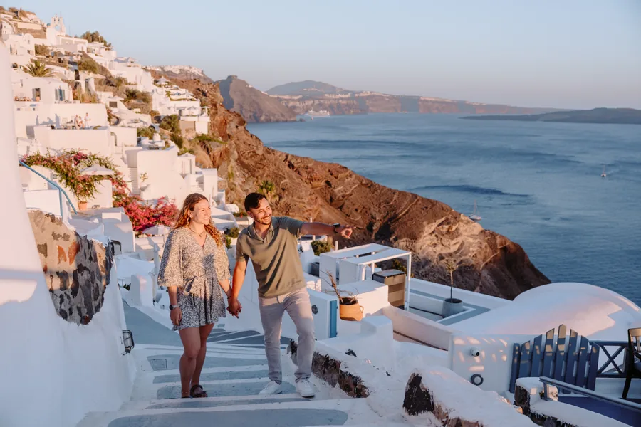 Walking down the steps, the white houses of Oia around them
