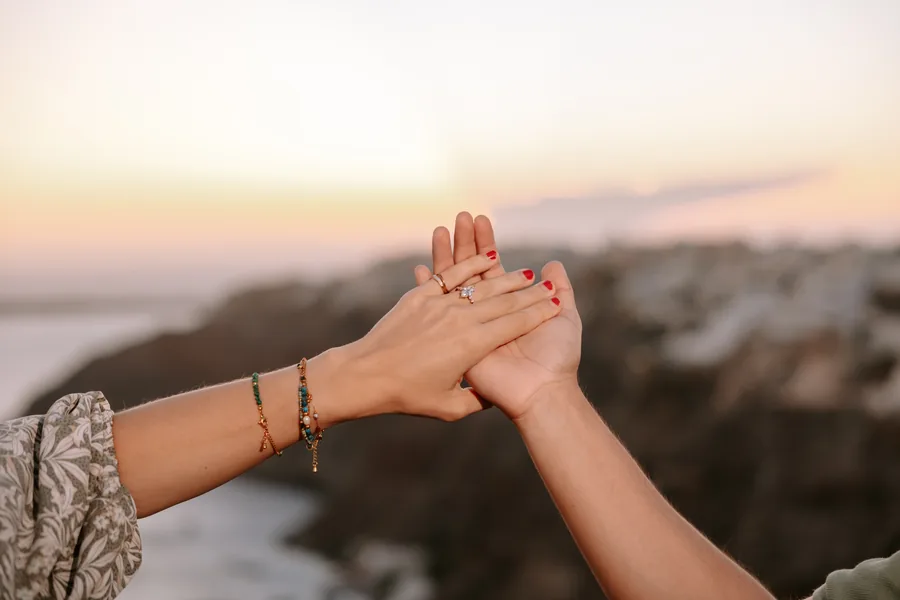 Hands held up against the sunset sky, the ring catching the light