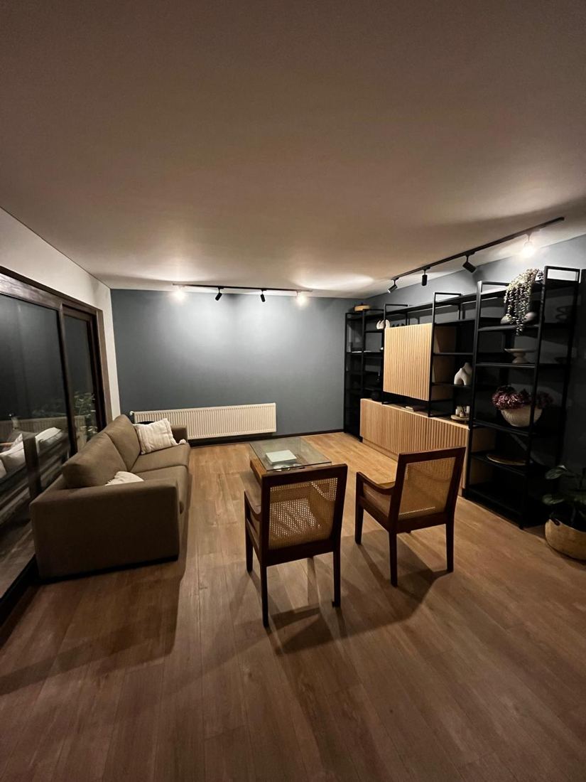 Living con piso vinílico nuevo, muro pintado e iluminación en riel