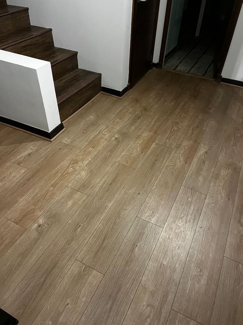 Piso vinílico imitación madera instalado en el hall junto a la escalera